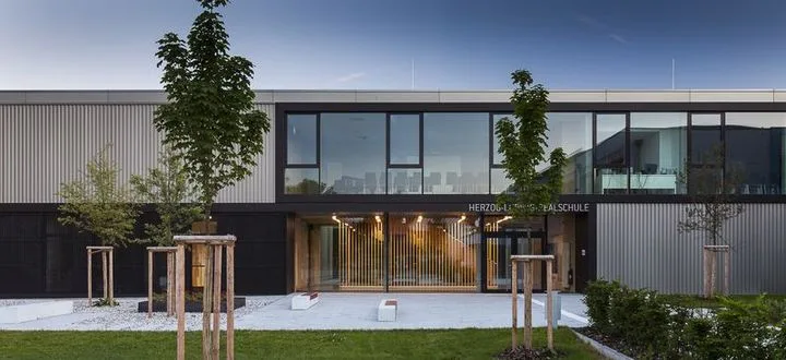 Eingangsbereich der Herzog-Ludwig-Realschule Altötting mit Holz-Alu-Fassade und Vordach