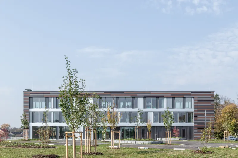 Betriebsgebäude Waldwasser Moos: Holz-Alu-Fassade in BSH-Eiche mit farbig gegliederter Paneelfassade, Gesamtansicht