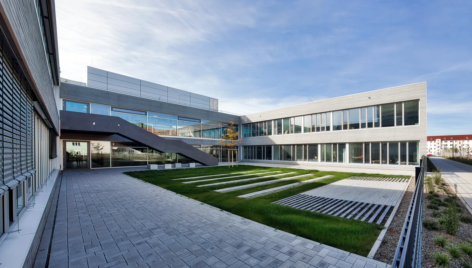 Pausenhof der Kreuzschule Regensburg mit Holz-Alu-Fensterbändern und außenliegendem Sonnenschutz